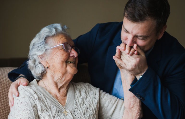 iStock-1179049284 man kissing his mother's hand
